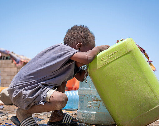 Ein Junge in Port Sudan trinkt aus einem Wasserkanister Ein Junge trinkt aus einem grünen Wasserkanister