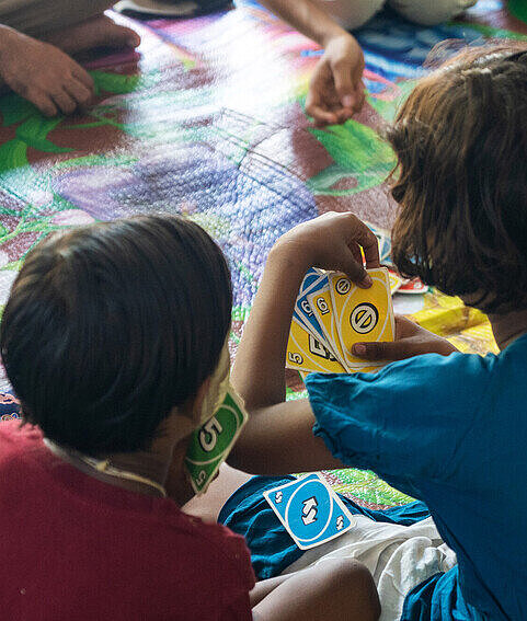 Auch Uno steht in den Kinderschutzräumen auf dem Spielplan Eine Gruppe Kinder spielt Uno