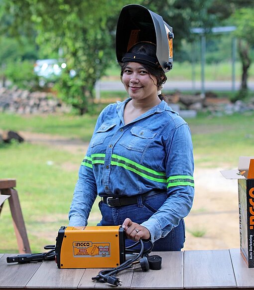 Lizzy mit Helm am Schweißgerät