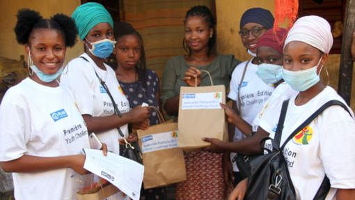 Gruppe von Mädchen hält Hygiene-Kits in Tüten.