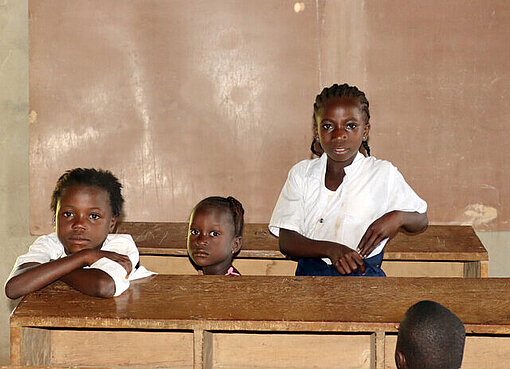 Drei Kinder in der neuen Schule in Lofa