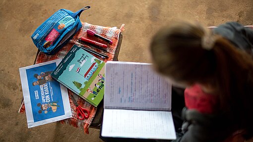 Lilian mit verschiedenen Schulmaterialien.