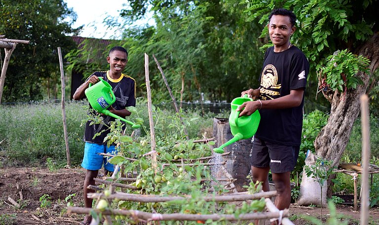 Paul und Taran bewässern Pflanzen 
