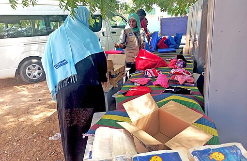 Frauen und Männer packen Pakete mit Hilfsgütern zusammen