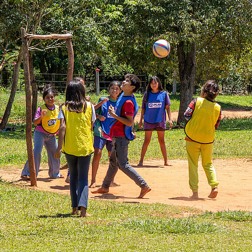 Draußen auf einem Fußballplatz spielen Kinder aus der Gemeinde Fußball