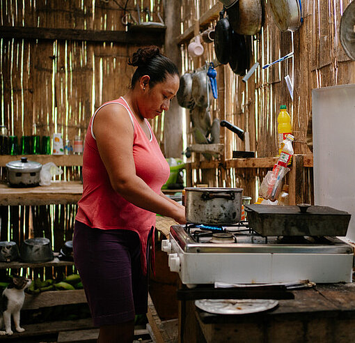 Mayra bereitet in der Küche ihres neu aufgebauten Hauses eine Mahlzeit zu.