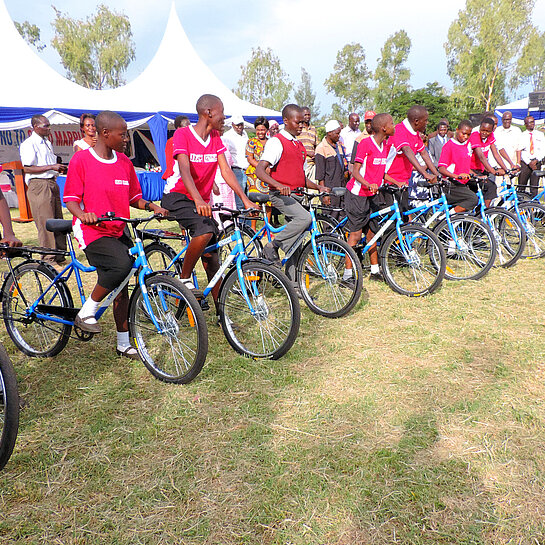 Gruppe von Schüler:innen mit roten Trikots und blauen Fahrrädern.