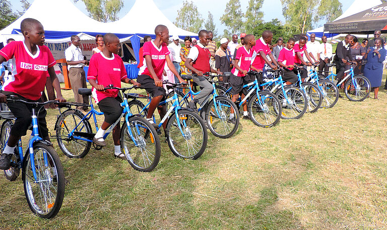 Gruppe von Schüler:innen mit roten Trikots und blauen Fahrrädern.