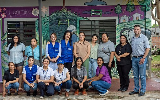 Eine Gruppe Frauen und Männer steht vor einem Gebäude