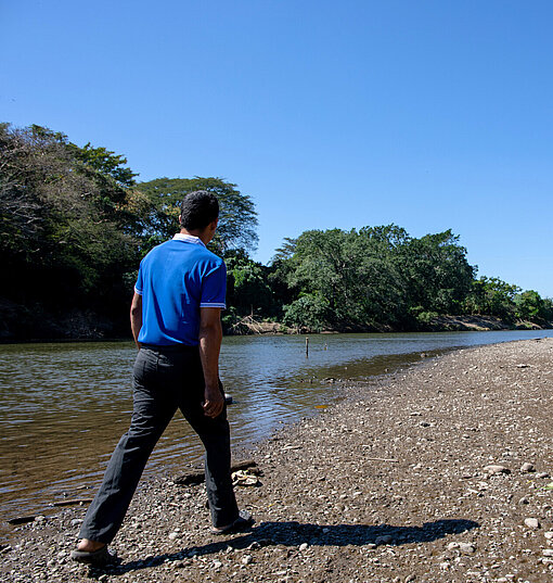 Ein Mann läuft am Flussufer des Río Lempa entlang