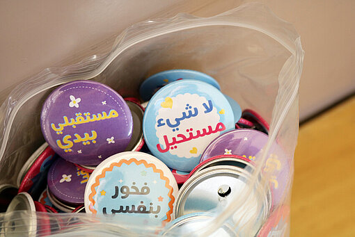 Eine Tüte mit Abzeichen, auf denen motivierende Botschaften für die Kinder drauf stehen