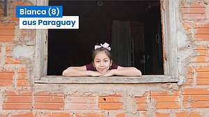 Bianca schaut aus dem Fenster ihres Wohnhauses.