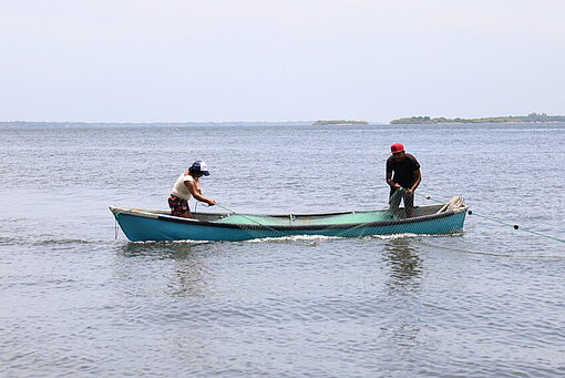 Ein kleines Fischerboot fährt in der Ferne auf dem Meer vor der Küste von El Salvador.