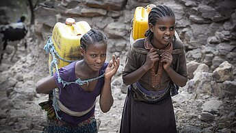 Im Norden Äthiopiens fehlt es wegen der Dürre an Trinkwasser. Es ist Aufgabe der Mädchen, das Wasser von den Ausgabestellen nach Hause zu schleppen. © Michael Tekele