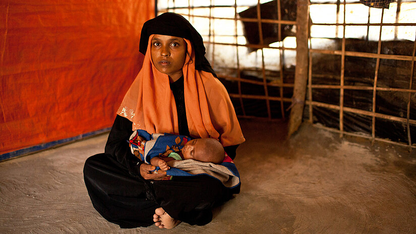 Die 20-jährige Yasmin muss jeden Tag Reiswasser für ihr Baby anrühren. Weil es nicht genug zu essen gibt, hat sie nicht genügend Milch. © Plan International/ Michael Rhebergen