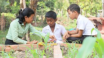 Keo bringt zwei Schülern den Umgang mit dem Winkelmesser bei