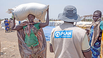 In Südsudan verteilen Plan-Teams Nahrungsmittel an bedürftige Frauen und Familien