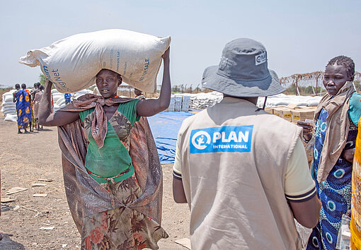 Eine Frau in Afrika mit einem Sack Nahrungsmittel