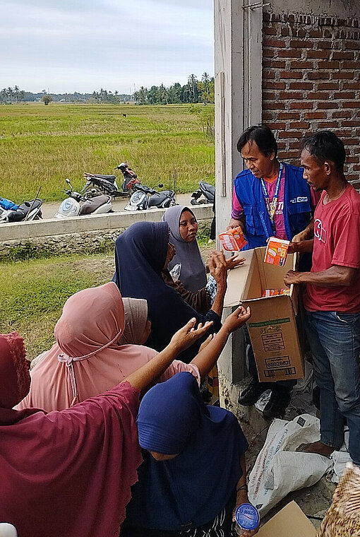 Frauen erhalten Binden vom Nothilfe-Team