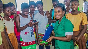 Schülerinnen in Ghana erhalten Aufklärung über Menstruation und waschbare Stoffbinden von einer Gesundheitshelferin