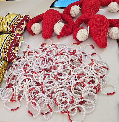 Menstruationszyklus-Armbänder, die dabei helfen sollen, den Zyklus besser zu verstehen und das Thema zu enttabuisieren Mehrere bunte Armbänder, die den Menstruationszyklus symbolisieren, liegen auf einem Tisch