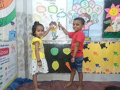 Kinder zeigen auf ein Plakat in einem kinderfreundlichen Raum