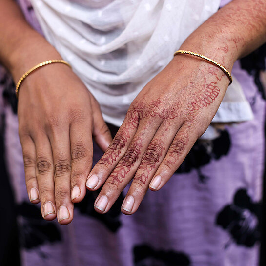 Das Foto zeigt die Hände eines Mädchens aus Bangladesch, die mit Henna-Tattoos für die Hochzeit verziert sind. 