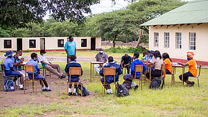 Gruppe von Schülern und Lehrkräften bei einer Unterrichtseinheit im Freien an einer Schule in Simbabwe