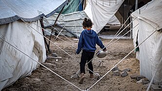 Ein Kind zwischen Zelten im Gazastreifen