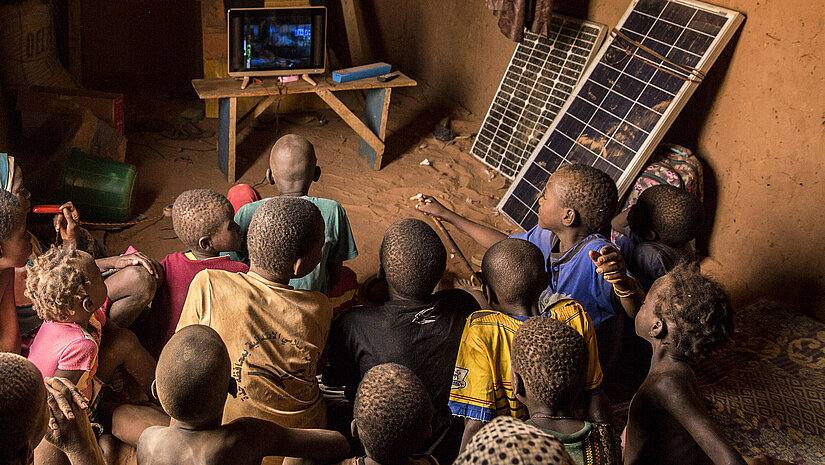 Die Kinder haben zuvor noch nie elektrisches Licht gesehen. Nun wird ihre Schule mit Strom versorgt und sie können sogar fernsehen. © Plan International/Olmo Calvo