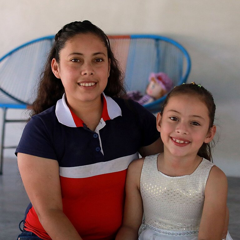 Ein kleines Mädchen und ihre Mutter sitzen auf der Veranda