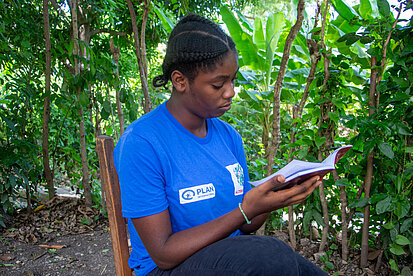Eine junge Frau blättert in einem Buch
